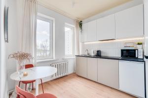 a kitchen with white cabinets and a white table at COMFISTAY Plac Piłsudskiego 8 - Rynek i Amfiteatr in Opole