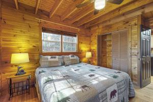 a bedroom with a bed in a log cabin at Bear’s Den in Sautee Nacoochee