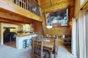 a dining room with a table and a kitchen at Whistle Stop Cabin in Lake Arrowhead