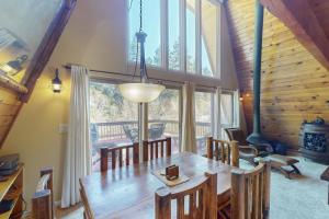 a dining room with a wooden table and a large window at Whistle Stop Cabin in Lake Arrowhead +45 photos