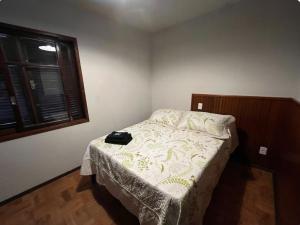 a small bedroom with a bed with at Alpininha kitnet in Bocaina de Minas