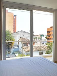 Un dormitorio con una cama y una ventana grande en 402 studio apartment in El Peñon, en Cali