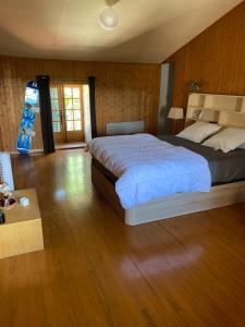 a bedroom with a large bed and a wooden floor at Belle maison en pierre avec piscine in Ucel