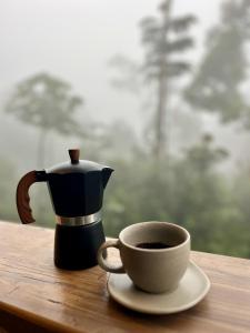 a coffee pot and a cup of coffee on a table at Paseo Por Las Nubes Birding Lodge in Chámeza