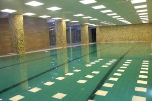 - une piscine dans un bâtiment avec un sol vert dans l'établissement Grand Alin Otel, à Turhal