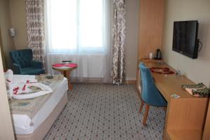 une chambre d'hôtel avec un lit, une table et un bureau dans l'établissement Grand Alin Otel, à Turhal