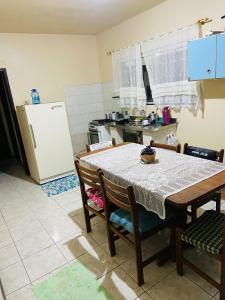 a kitchen with a table and chairs and a refrigerator at Lindo Sobrado SFS Enseada Beach in São Francisco do Sul