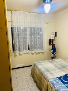 a bedroom with a bed and a window at Lindo Sobrado SFS Enseada Beach in São Francisco do Sul
