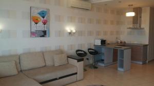 ein Wohnzimmer mit einem Sofa und einer Küche in der Unterkunft Most City Premium apartments in Dnipro