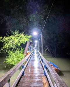 un ponte sopra un fiume di notte con un lampione di Casa em Maruda a Marapanim