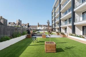 un jardin avec une table et un pot sur un bâtiment dans l'établissement The Stag City Centre Cosy 1 Bed Long Term Stays Welcome, à Plymouth