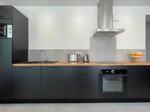 una cucina con armadi neri e lavandino di Appartement Aqua-Villas Lake And Sea a Seignosse Altre 12 foto