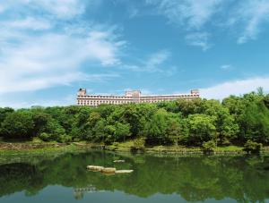 um edifício situado no topo de uma colina ao lado de um lago em Hotel Sekia em Sekimachi