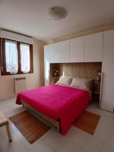 a bedroom with a large bed with a pink blanket at Casa Dolce Paola in Cagliari