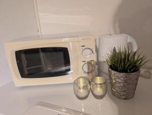 a microwave sitting on top of a counter with plants at Koselig kjellerleilighet, gratis parkering! in Trondheim