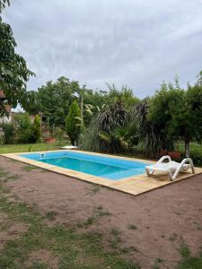 a swimming pool with two white chairs next to it at Descanso el abuelo in Londres +4 photos