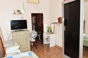 a living room with a television and a dresser at Casa com Quarto Duplo com Banheiro Privativo in Rio de Janeiro