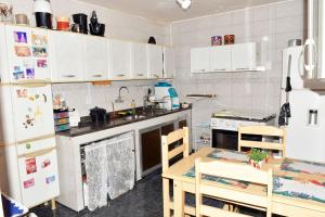 a kitchen with white cabinets and a table and chairs at Casa com Quarto Duplo com Banheiro Privativo in Rio de Janeiro