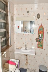 a bathroom with a sink and a mirror at Casa com Quarto Duplo com Banheiro Privativo in Rio de Janeiro