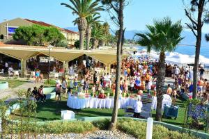 a crowd of people sitting around tables at a party at Ephesia Holiday Beach Club in Kuşadası