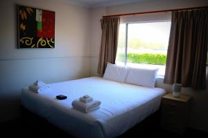 Ένα ή περισσότερα κρεβάτια σε δωμάτιο στο The Commercial Hotel Motel