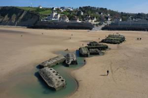 un groupe de vieux pneus dans le sable sur une plage dans l'établissement Appartement Cosy Cœur de la Normandie, à Creully 2 autres photos