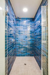 a blue tiled bathroom with a glass shower at View of Hollywood Sign Studio, Free Parking in Los Angeles