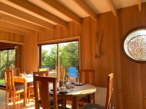 a dining room with a table and chairs and a window at Lodge Cumbres de Chiloe in Castro