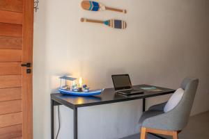 escritorio con ordenador portátil y bate de béisbol en Nomad Palmeira Duplex com Hidromassagem privativa, en Porto de Pedras