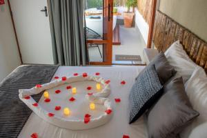 un pastel en una cama con corazones rojos. en Nomad Palmeira Duplex com Hidromassagem privativa, en Porto de Pedras