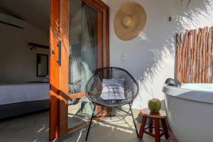 Habitación con silla, bañera y cama en Nomad Palmeira Duplex com Hidromassagem privativa, en Porto de Pedras 34 fotos más