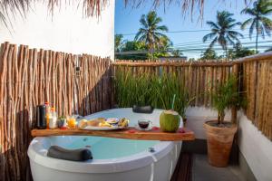 bañera con bandeja de comida en el patio en Nomad Palmeira Duplex com Hidromassagem privativa, en Porto de Pedras
