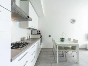 cocina blanca con mesa blanca y fogones en Crêuza de mä - tranquillità e natura ad Alassio, en Alassio