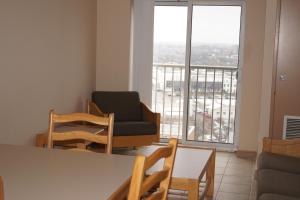 a living room with a table and chairs and a balcony at Hotel Laurier - Apartment Style Residence in Waterloo