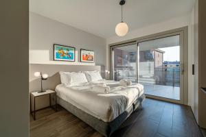 a bedroom with a large bed and a large window at Cremona Inn Aparthotel in Cremona