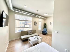 a living room with a couch and a table at Urban Oasis Downtown Condo with Skywalk Access 4 in Des Moines