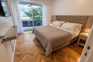 a bedroom with a bed and a large window at Aparthotel Trianon Recoleta in Buenos Aires