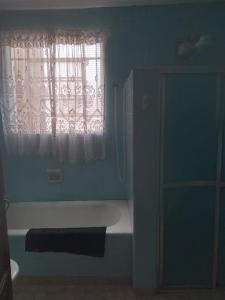 a bathroom with a bath tub and a window at Hostel Baladi in Socorro +2 photos