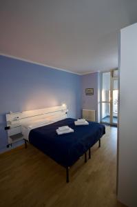 a blue bedroom with a bed with two towels on it at H2ome - Il Cembalo vista baia e città balcone o terrazzo parcheggio su richiesta in Genova
