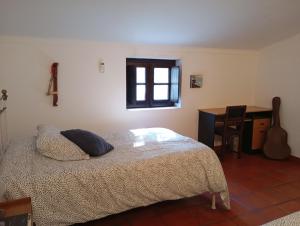 a bedroom with a bed and a desk with a guitar at Monte da Samarra in Avis +55 photos