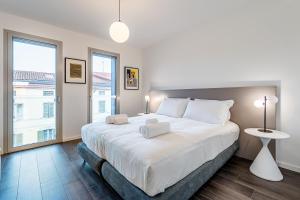 a bedroom with a large white bed and a large window at Cremona Inn Aparthotel in Cremona +60 photos