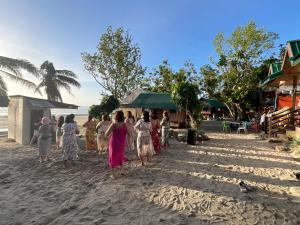 a group of people walking on the beach at Diva Sunrise beach resort in Dipaculao
