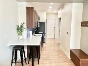 a kitchen with a white counter and a black refrigerator at Urban Oasis Downtown Condo with Skywalk Access 5 in Des Moines +15 photos
