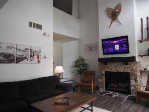 a living room with a couch and a fireplace at Modern Town at Wintergreen 2min walk to Village Sauna in Blue Mountains