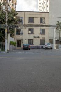 dois carros estacionados em frente a um edifício em 2 dorm em um prédio charmoso da decada de 1950 em São Paulo