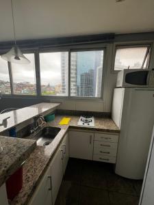 ベロオリゾンテにあるRaja Flatのキッチン(シンク、冷蔵庫付)、窓が備わります。