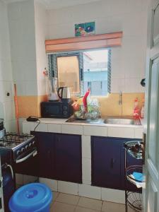 eine kleine Küche mit Spüle und Fenster in der Unterkunft Résidence Meublée Pachira I in Abidjan