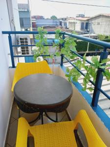ein Tisch und zwei Stühle auf einem Balkon in der Unterkunft Résidence Meublée Pachira I in Abidjan