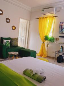 ein Wohnzimmer mit einem Bett und einem grünen Sofa in der Unterkunft Résidence Meublée Pachira I in Abidjan