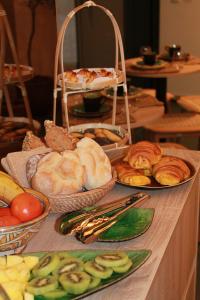 a table topped with different types of bread and pastries at O Laranjal in Guimarães